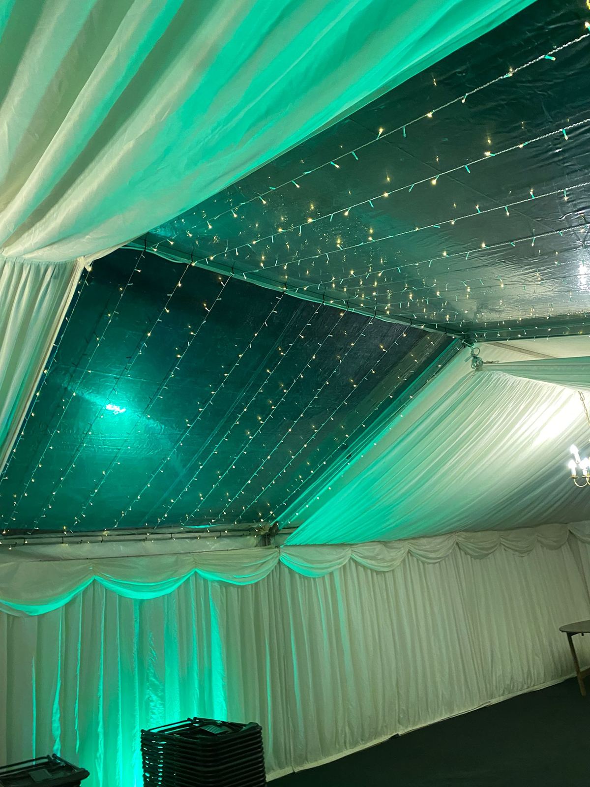 Marquee ceiling with fairy lights and coloured uplighting