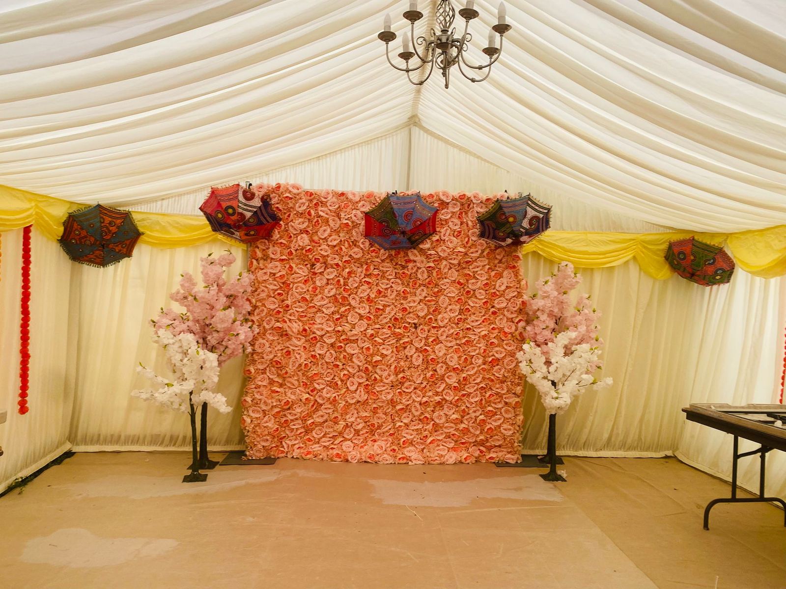 Marquee styled with rose flower wall and parasols