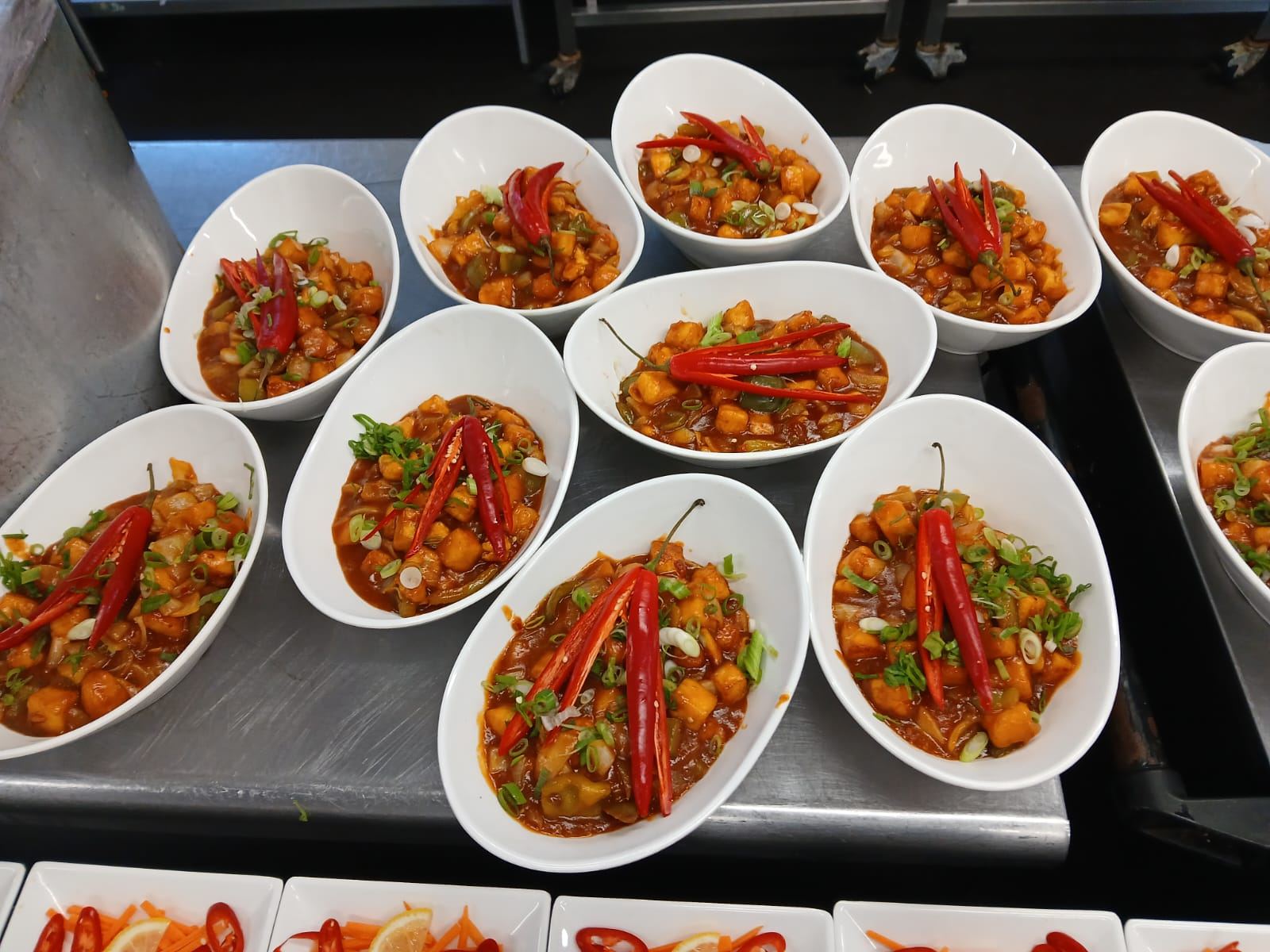 Chilli paneer plated with fresh red chillies
