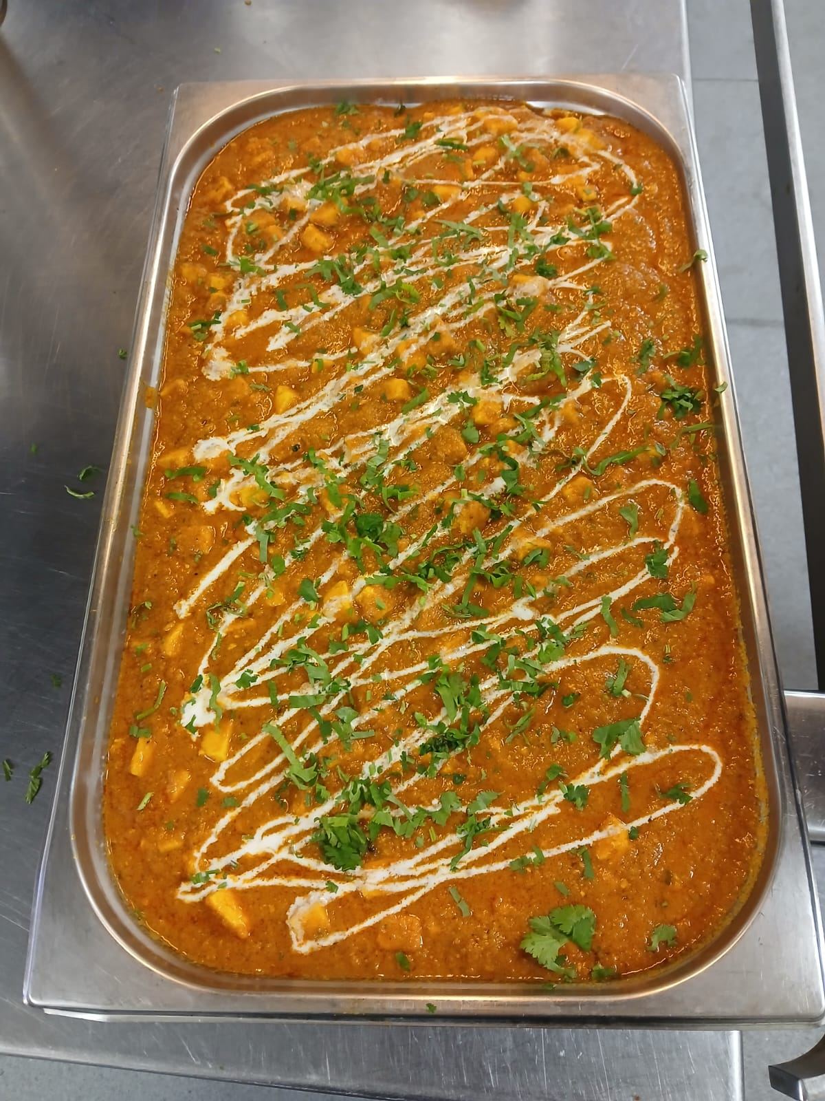 Rich paneer curry garnished with cream and coriander
